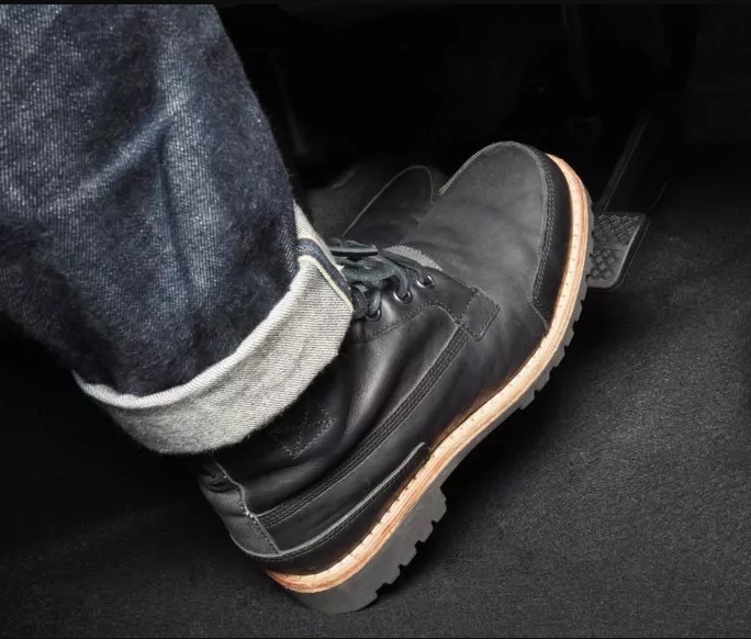The foot of a Toyota forklift operator pressing against a loose brake pedal